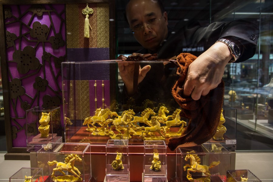 Hong Kong, China An employee arranges a display of gold horse figurines in the window of a Chow Sang Sang Holdings International Ltd. jewelry store in the Mongkok district of Hong Kong, China, on January 30.