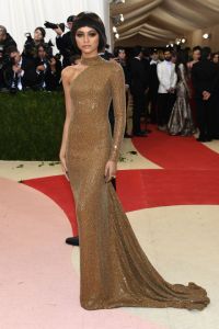 Zendaya keeps it simple yet impactful in a gilded one-shoulder Michael Kors gown with a train and turtleneck detail.