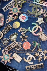 clusters of CHANEL pins on denim jacket